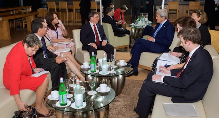 U.S. Secretary of State John Kerry and Cuban Foreign Minister Bruno RodrÌguez, flanked by their respective advisers, sit together in Panama City, Panama in this handout photo