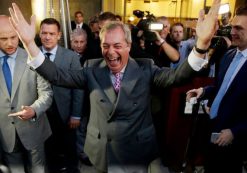 Nigel Farage, the leader of the UK Independence Party celebrates and poses for photographers as he leaves a 