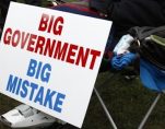 A protestor rests next to their big government big mistake sign. (Photo: Reuters)