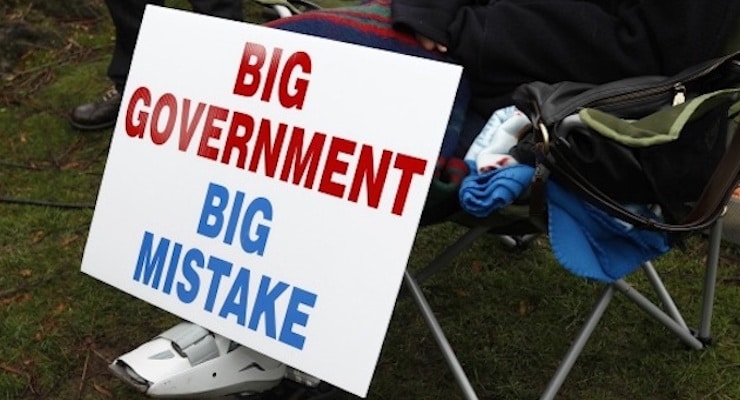 A protestor rests next to their big government big mistake sign. (Photo: Reuters)