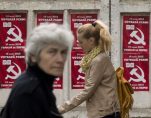 Pedestrians walk past election posters for the Communist Party in Chisinau, the capital city of Moldova. Repeated attempts to sell radioactive materials signal that a thriving nuclear black market has emerged in this impoverished corner of Eastern Europe on the fringes of the former Soviet Union. (AP Photo/Vadim Ghirda)
