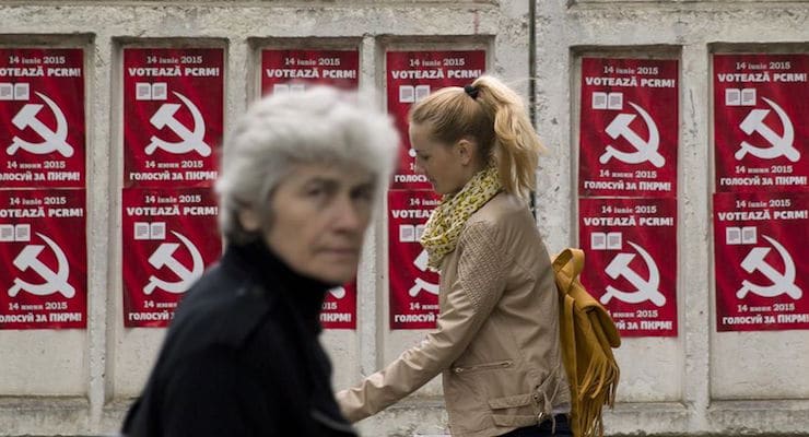 Pedestrians walk past election posters for the Communist Party in Chisinau, the capital city of Moldova. Repeated attempts to sell radioactive materials signal that a thriving nuclear black market has emerged in this impoverished corner of Eastern Europe on the fringes of the former Soviet Union. (AP Photo/Vadim Ghirda)