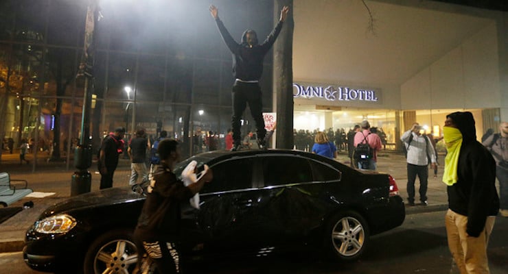 Demonstrators protest Tuesday's fatal police shooting of Keith Lamont Scott in Charlotte, N.C. on Wednesday, Sept. 21, 2016. Protesters rushed police in riot gear at a downtown Charlotte hotel and officers have fired tear gas to disperse the crowd. At least one person was injured in the confrontation, though it wasn't immediately clear how. Firefighters rushed in to pull the man to a waiting ambulance. (Photo: AP/Associated Press)