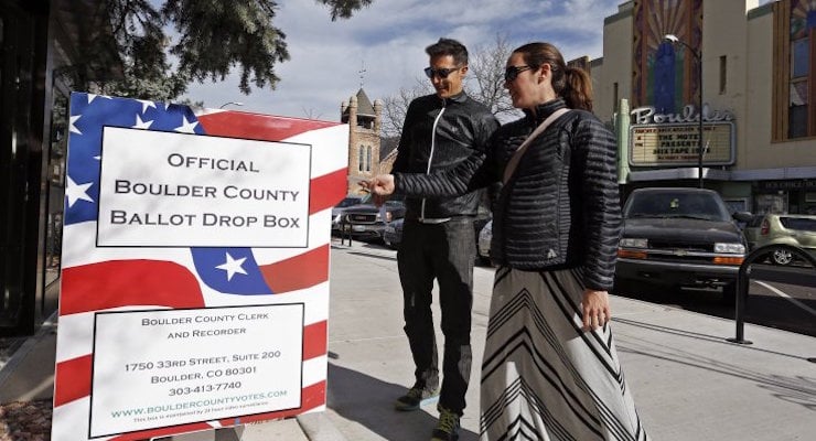 Megan Monroe, right, and Brian Fuentes drop of their ballots at an electoral drop box, in Boulder, Colo., Friday, Oct. 31, 2014. Mail-in voting in Colorado means that most voters cast their ballots before Election Day. (Photo: Associated Press/AP)
