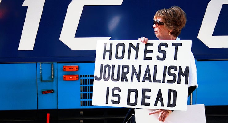 media-bias An American voter holds a "Honest Journalism is Dead" sign at a rally.