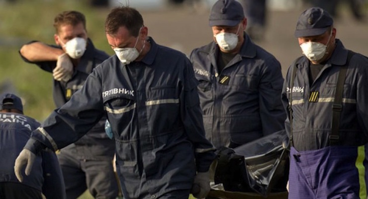 July 19, 2014: Emergency workers carry the body of a victim at the crash site of Malaysia Airlines Flight 17 near the village of Hrabove, eastern Ukraine. (Photo: AP Photo/Vadim Ghirda)