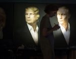 A journalist writes a material as she watches a live telecast of the U.S. presidential election standing at portraits of U.S. presidential candidate Donald Trump and Russian President Vladimir Putin in the Union Jack pub in Moscow, Russia, Wednesday, Nov. 9, 2016. Russia's lower house of parliament is applauding the election of Trump as U.S. president. (Photo: AP)
