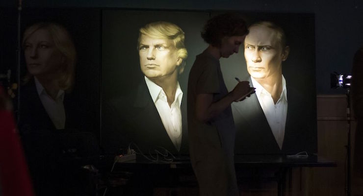 A journalist writes a material as she watches a live telecast of the U.S. presidential election standing at portraits of U.S. presidential candidate Donald Trump and Russian President Vladimir Putin in the Union Jack pub in Moscow, Russia, Wednesday, Nov. 9, 2016. Russia's lower house of parliament is applauding the election of Trump as U.S. president. (Photo: AP)
