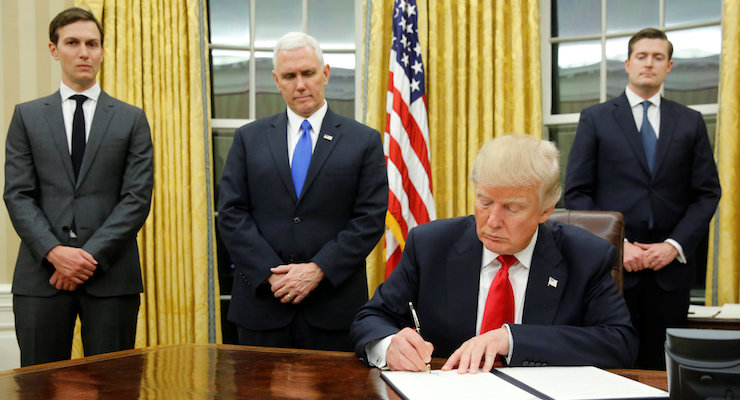 U.S. President Donald Trump, signs his first executive orders at the White House on Friday. Behind him, from left, are senior adviser Jared Kushner, Vice President Mike Pence and staff secretary Rob Porter. (Photo: Reuters)