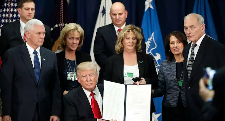 President Donald J. Trump, center, sits to the left of Vice President Mike Pence, to the right of Homeland Security Secretary John F. Kelly, while holding up an executive order to build border wall and fulfill other campaign promises related to immigration. The orders were signed at the U.S. Department of Homeland Security on Wednesday, Jan. 25, 2017 in Washington. (Photo: AP)