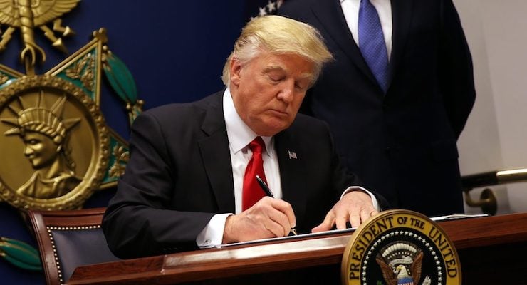 President Donald J. Trump signs an executive order to impose tighter vetting of travelers entering the United States on January 27, 2017. (Photo: Reuters)