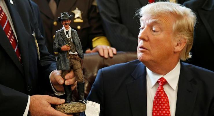President Donald J. Trump receives a figurine of a sheriff during a meeting with county sheriffs at the White House. (Photo: Reuters)