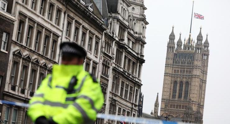 A police officer stands on duty as the union flag flies over Parliament at half-mast. (Photo: Reuters)