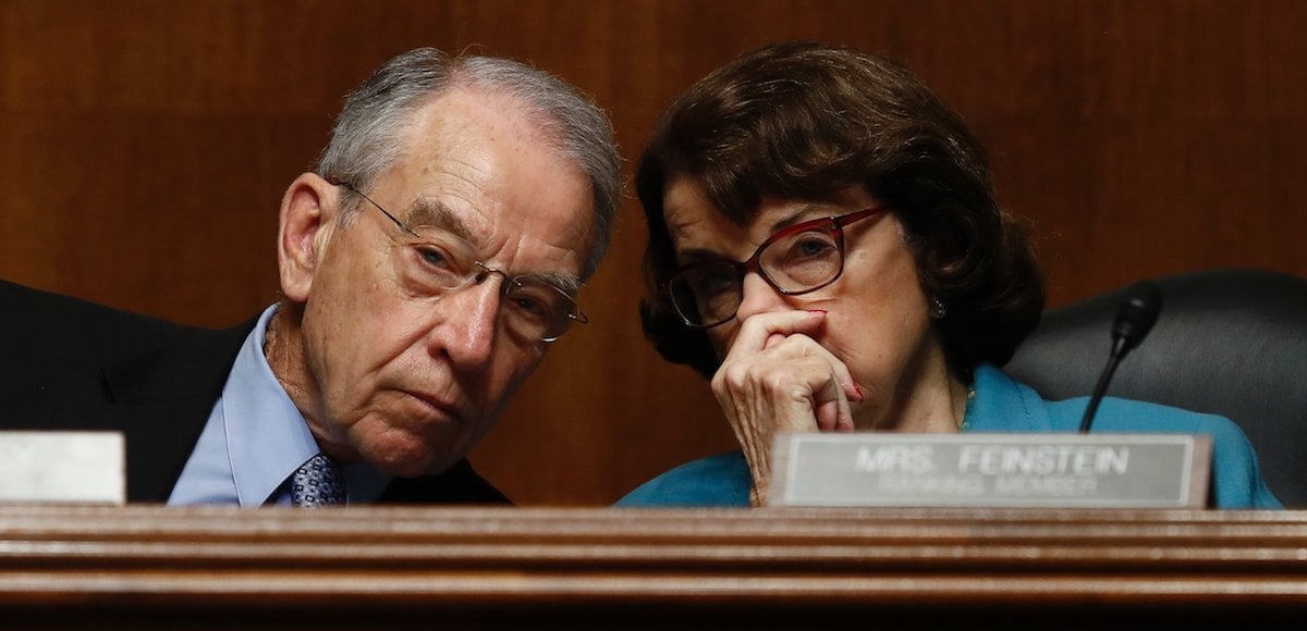 Sen. Dianne Feinstein, D-Calif., whispers something into the ear of her colleague Sen. Chuck Grassley, R-Ia., during a Senate hearing. (Photo: AP)