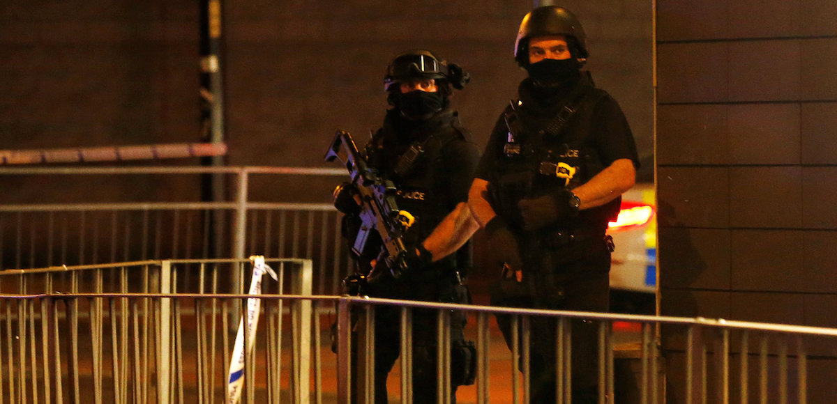 Armed police officers stand next to a police cordon outside the Manchester Arena, where U.S. singer Ariana Grande had been performing, in Manchester, northern England, Britain, May 23, 2017. (Photo: Reuters)