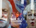 Workers in protective equipment are reflected in the window of a betting shop with a display inviting customers to place bets on tbe result of the general election with images of Britain's Prime Minister Theresa May and opposition Labour Party leader Jeremy Corbyn, in London, June 7, 2017. (Photo: Reuters)