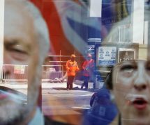 Workers in protective equipment are reflected in the window of a betting shop with a display inviting customers to place bets on tbe result of the general election with images of Britain's Prime Minister Theresa May and opposition Labour Party leader Jeremy Corbyn, in London, June 7, 2017. (Photo: Reuters)