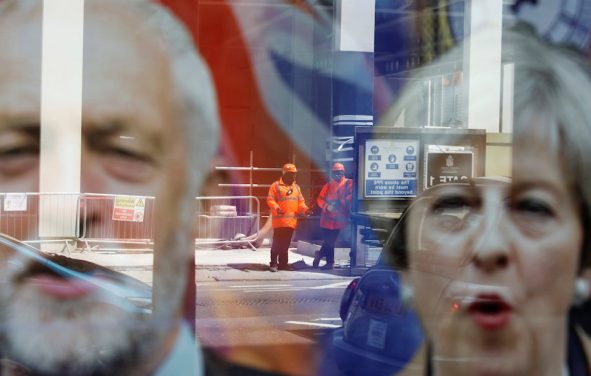 Workers in protective equipment are reflected in the window of a betting shop with a display inviting customers to place bets on tbe result of the general election with images of Britain's Prime Minister Theresa May and opposition Labour Party leader Jeremy Corbyn, in London, June 7, 2017. (Photo: Reuters)