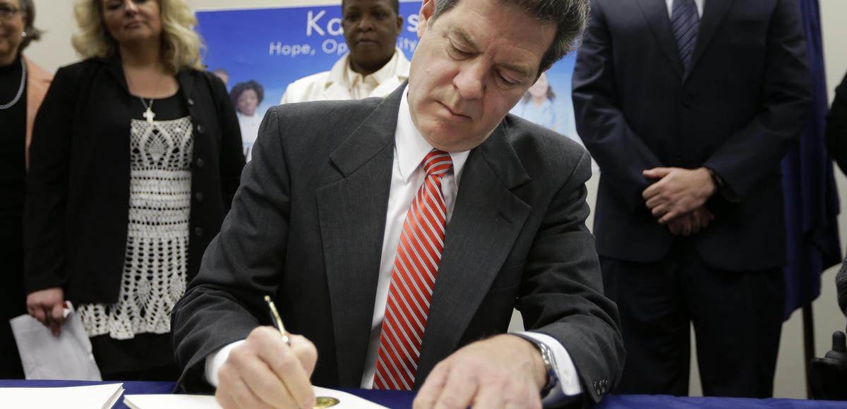 Gov. Sam Brownback signs a welfare reform bill into law in Topeka, Kan., Thursday, April 16, 2015. (Photo: AP)