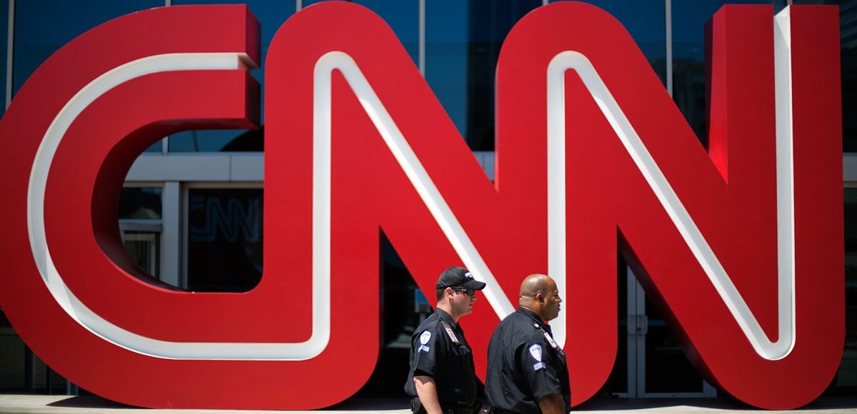 Security guards walk past the entrance to CNN headquarters in Atlanta. (Photo: AP)