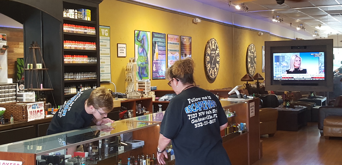 File: Mary Ewing, co-owner of Escape to Vape, an e-cigarette and vapor supply store located in Gainesville, Florida, discusses new mods with an employee on June 30, 2017. (Photo: People's Pundit Daily/PPD)
