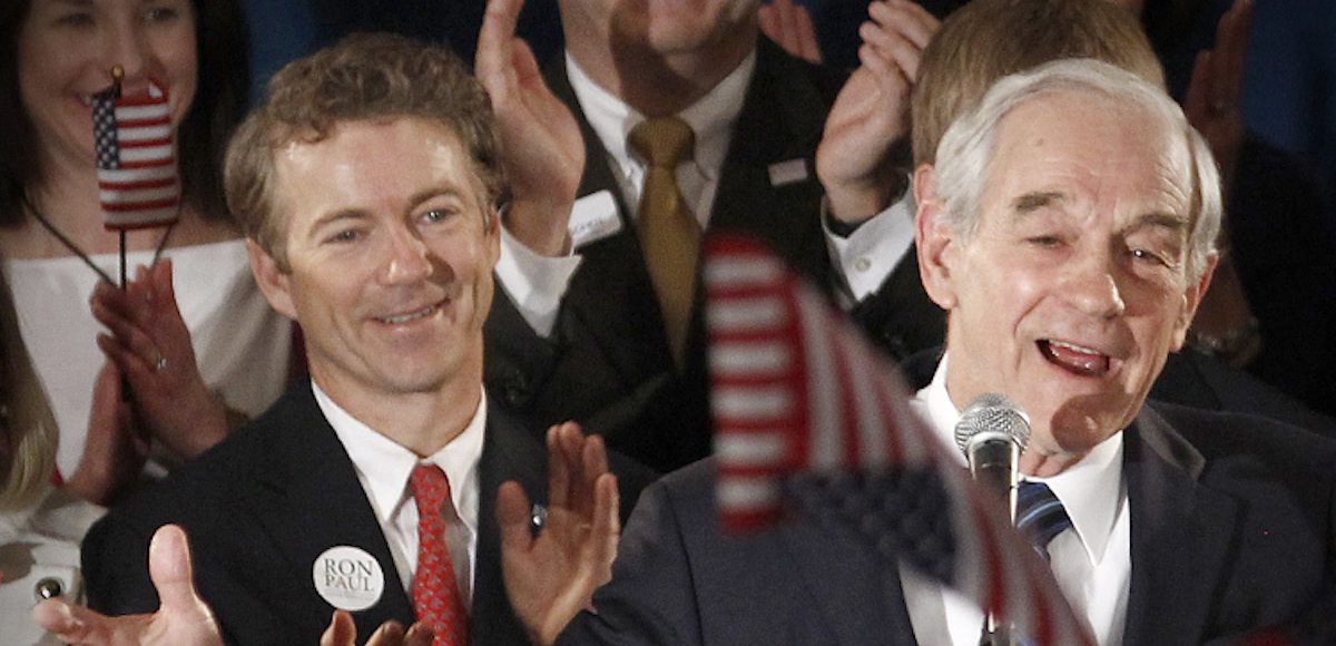 Then-Republican presidential candidate Rep. Ron Paul, a libertarian-leaning Republican from Texas, speaks to supporters as his son Sen. Rand Paul, Kty., also a libertarian-leaning Republican, applauds at his Iowa Caucus night rally in Ankeny, Iowa, January 3, 2012. (Photo: Reuters)