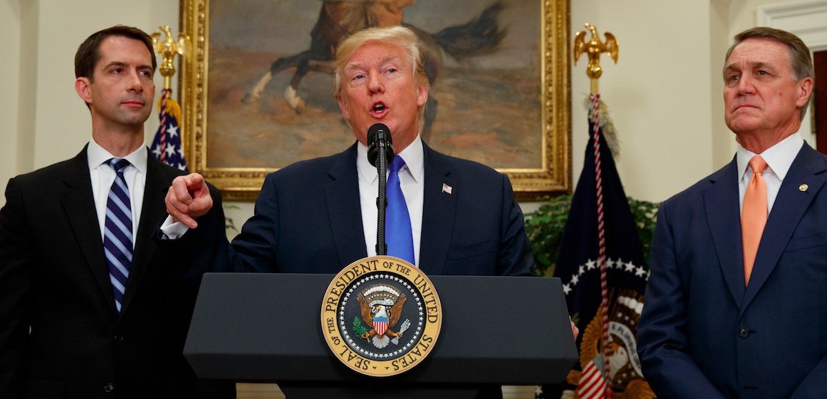 President Donald J. Trump, center, announces his support for the RAISE Act, flanked by Sens. Tom Cotton, R-Ark., left, and David Perdue, R-Ga., who first introduced similiar legislation. (Photo: Reuters)