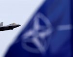U.S. and North Atlantic Treaty Organization (NATO) flags flutter as U.S. Air Force F-22 Raptor fighter flies over the military air base in Siauliai, Lithuania, April 27, 2016. (Photo: Reuters)
