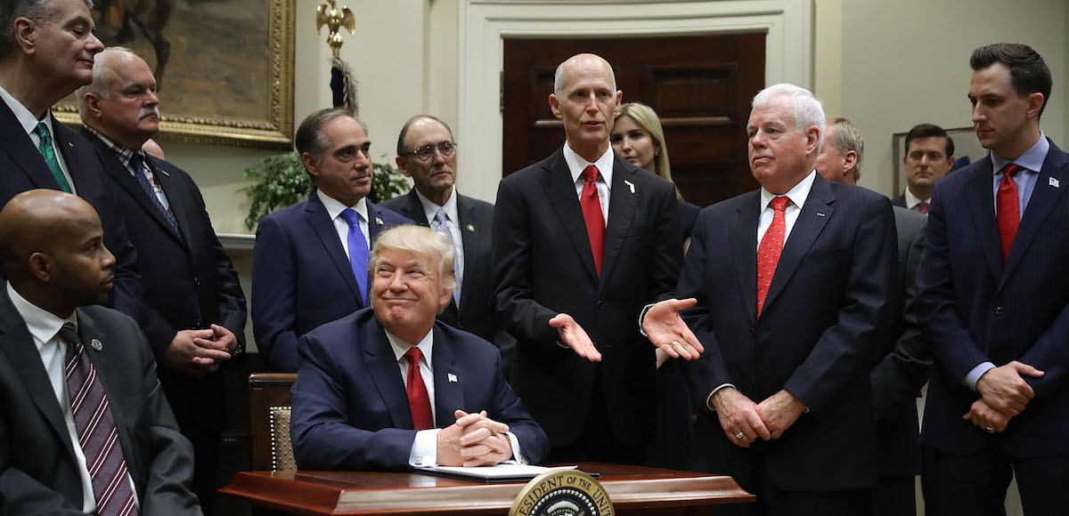 Florida Gov. Rick Scott, center, delivers brief remarks after President Donald J. Trump signed the Veterans Choice Program And Improvement Act with representatives of veterans’ organizations, politicians and members of his administration, including Veterans Affairs Secretary David Shulkin, in the Roosevelt Room at the White House on Wednesday in Washington, DC. (Photo: Reuters)