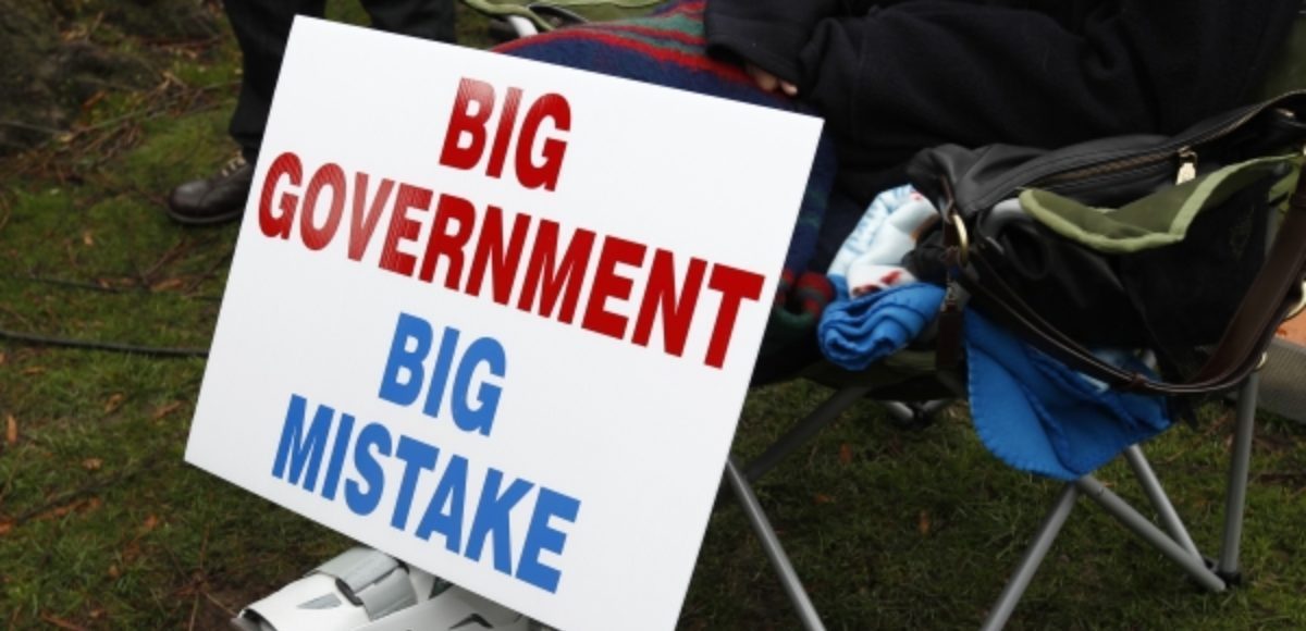 A protestor rests next to their big government big mistake sign. (Photo: Reuters)