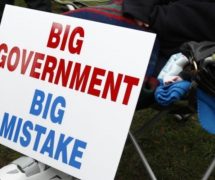 A protestor rests next to their big government big mistake sign. (Photo: Reuters)