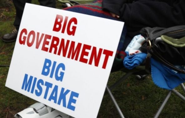 A protestor rests next to their big government big mistake sign. (Photo: Reuters)