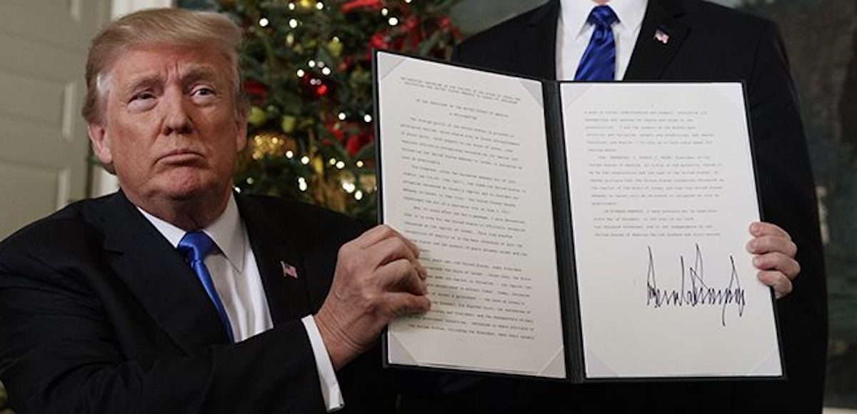 President Donald Trump in the Diplomatic Reception Room of the White House signs an order beginning the process of moving the U.S. Embassy in Tel Aviv, Israel to Jerusalem on December 6, 2017.