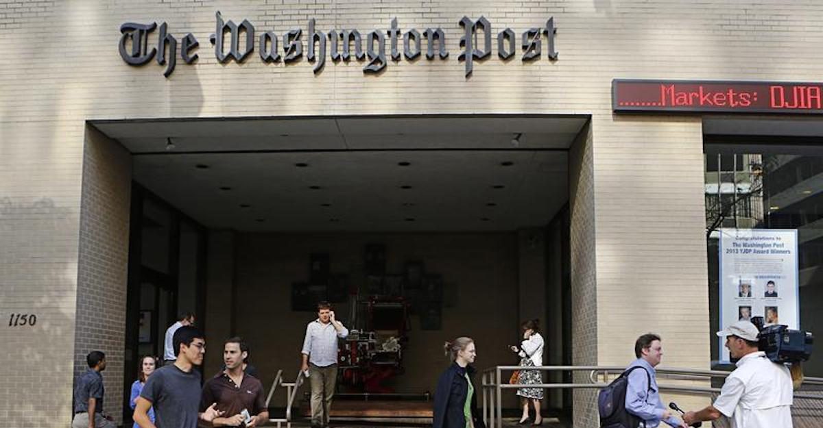 A television cameraman takes up a position as people walk by the entrance of the Washington Post headquarters in Washington, August 5, 2013. (Photo: Reuters)