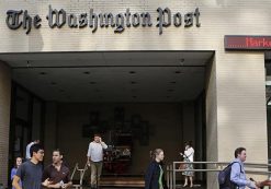 A television cameraman takes up a position as people walk by the entrance of the Washington Post headquarters in Washington, August 5, 2013. (Photo: Reuters)