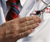 A doctor puts his hand over his chest during a 