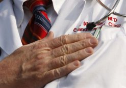 A doctor puts his hand over his chest during a 