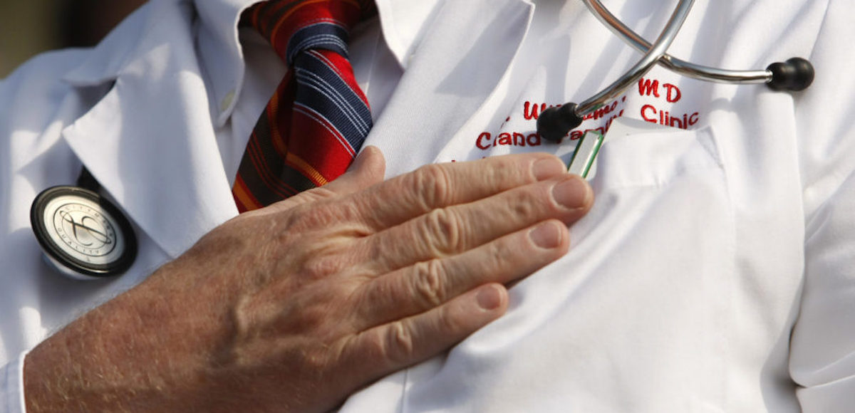 A doctor puts his hand over his chest during a "House call" rally against proposed healthcare reform legislation at the Capitol in Washington November 5, 2009. (Photo: Reuters)