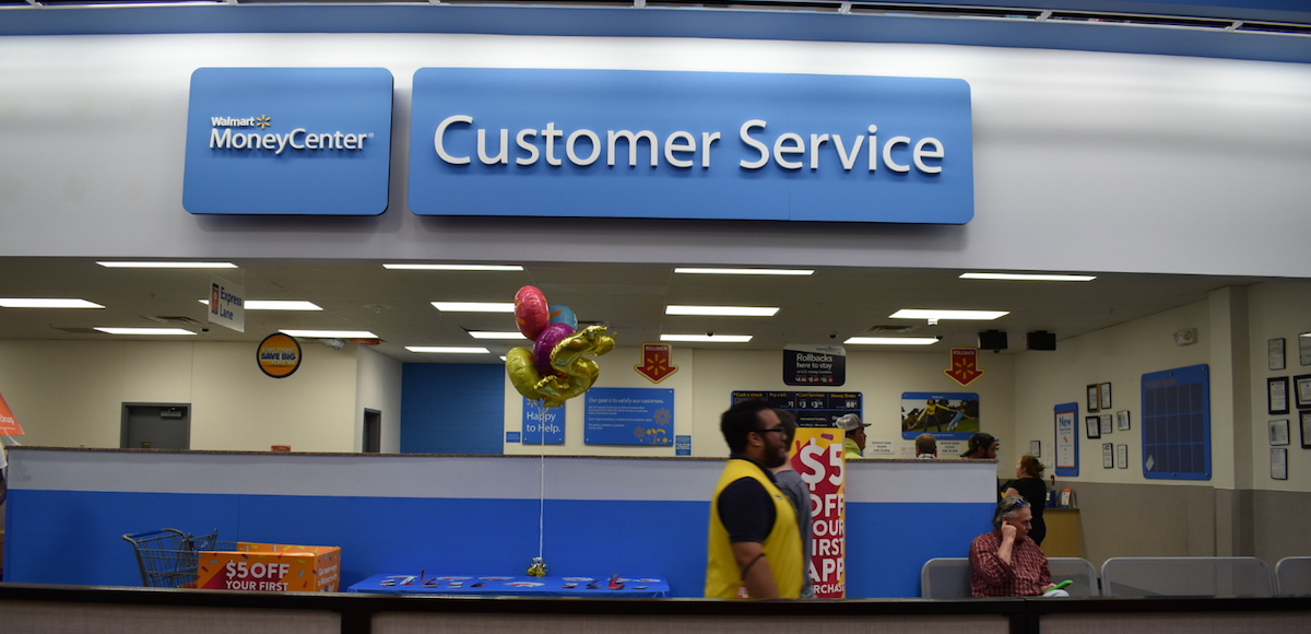 A Walmart employee who serves as a "customer host," walks in front of the customer service desk at a Walmart super-center location in Gainesville, Florida. (Photo: People's Pundit Daily/PPD)