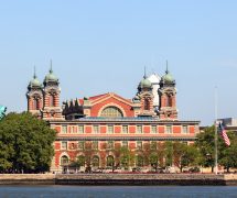 The Statue of Liberty in front of Ellis Island across from New York City. (Photo: AdobeStock/UbjsP)
