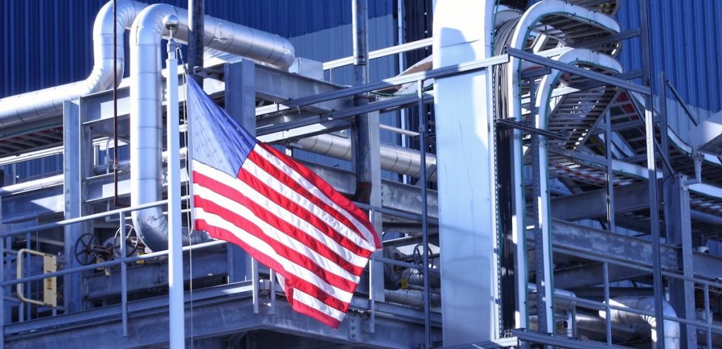 An American Flag flying in front of a U.S. manufacturing factory. (Photo: AdobeStock)