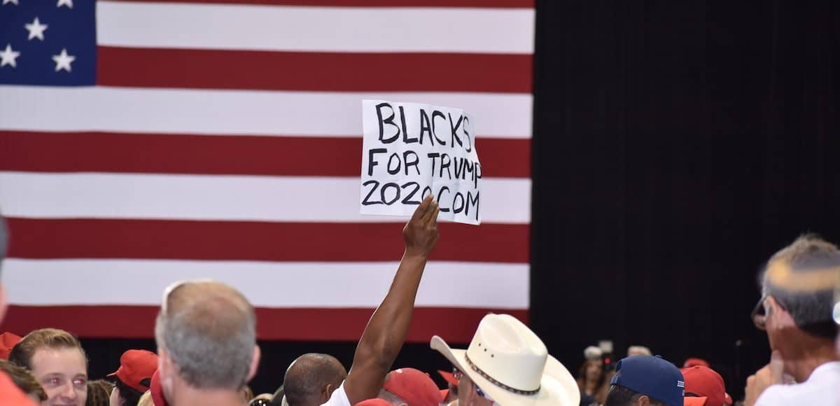 An African American supporter of President Donald Trump holds up a Black for Trump sign during a rally in Tampa, Florida on Tuesday, July 31, 2018. (Photo: Laura Baris/People's Pundit Daily)