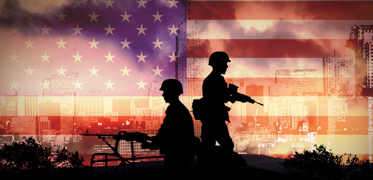 Silhouettes of U.S. soldiers on a Humvee in front of an American flag. (Photo: AdobeStock)