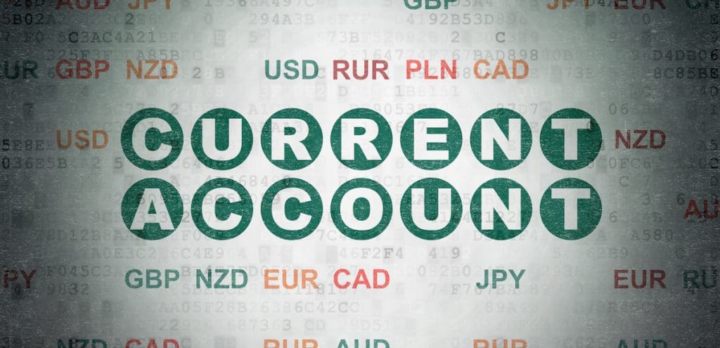 Current account balance concept: painted green text Current Account on digital data paper background with currency. (Photo: AdobeStock)