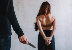 Kidnapping, human and sex trafficking concept of a female hostage and a man holding knife in an abandoned house. (Photo: AdobeStock)
