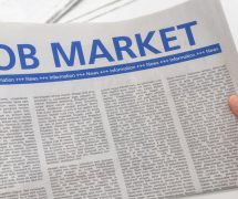 Man reading newspaper with the headline Job Market. (Photo: AdobeStock)