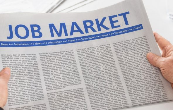 Man reading newspaper with the headline Job Market. (Photo: AdobeStock)