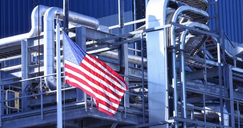 An American Flag flying in front of a U.S. manufacturing factory. (Photo: AdobeStock)