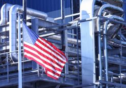 An American Flag flying in front of a U.S. manufacturing factory. (Photo: AdobeStock)