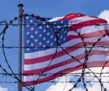 An American flag flying behind barbed wire at the U.S. southern border with Mexico. (Photo: AdobeStock)
